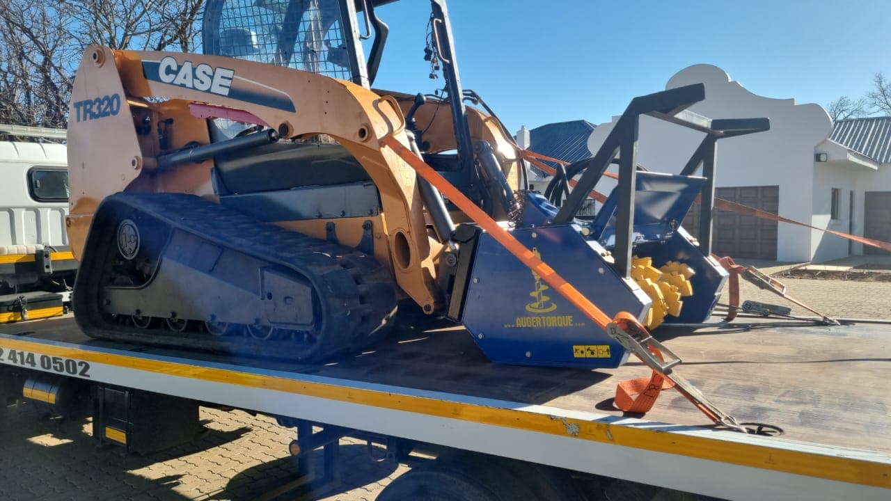 Loader equipment strapped down on a flatbed truck
