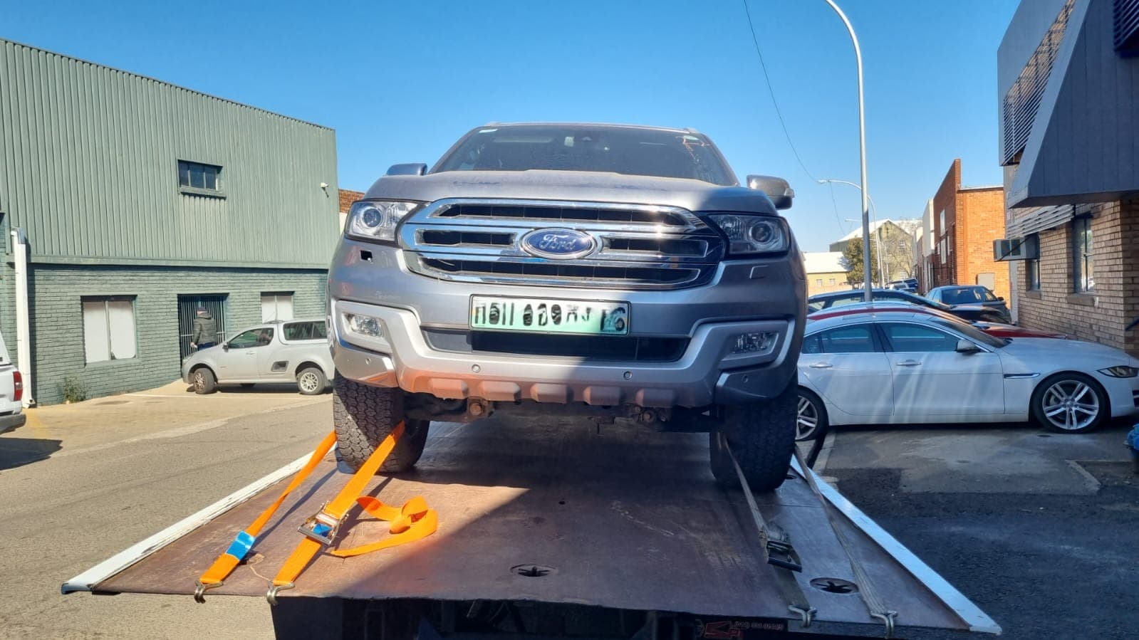 Pickup truck secured on a flatbed tow truck