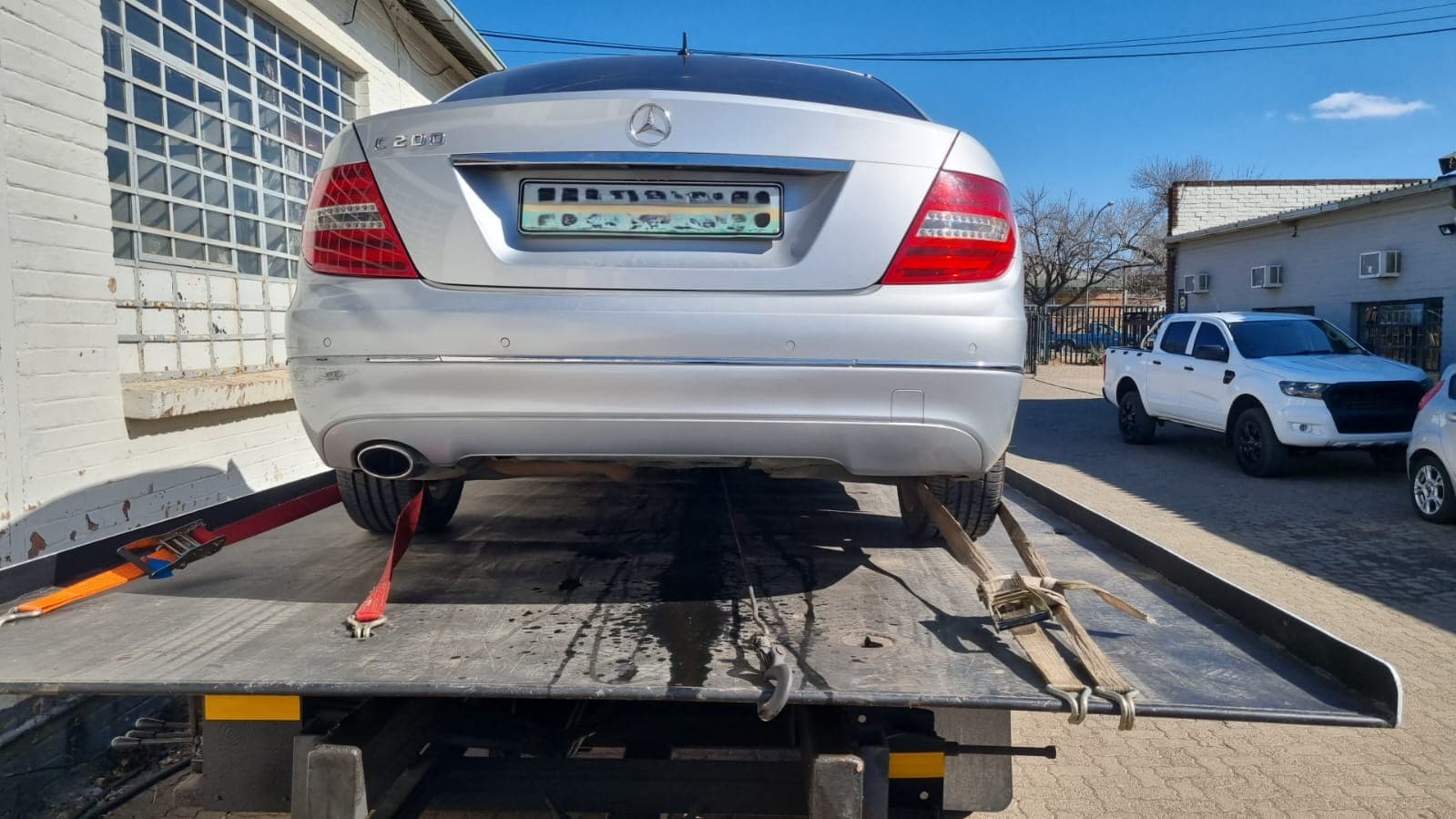 Silver sedan loaded onto a flatbed tow truck
