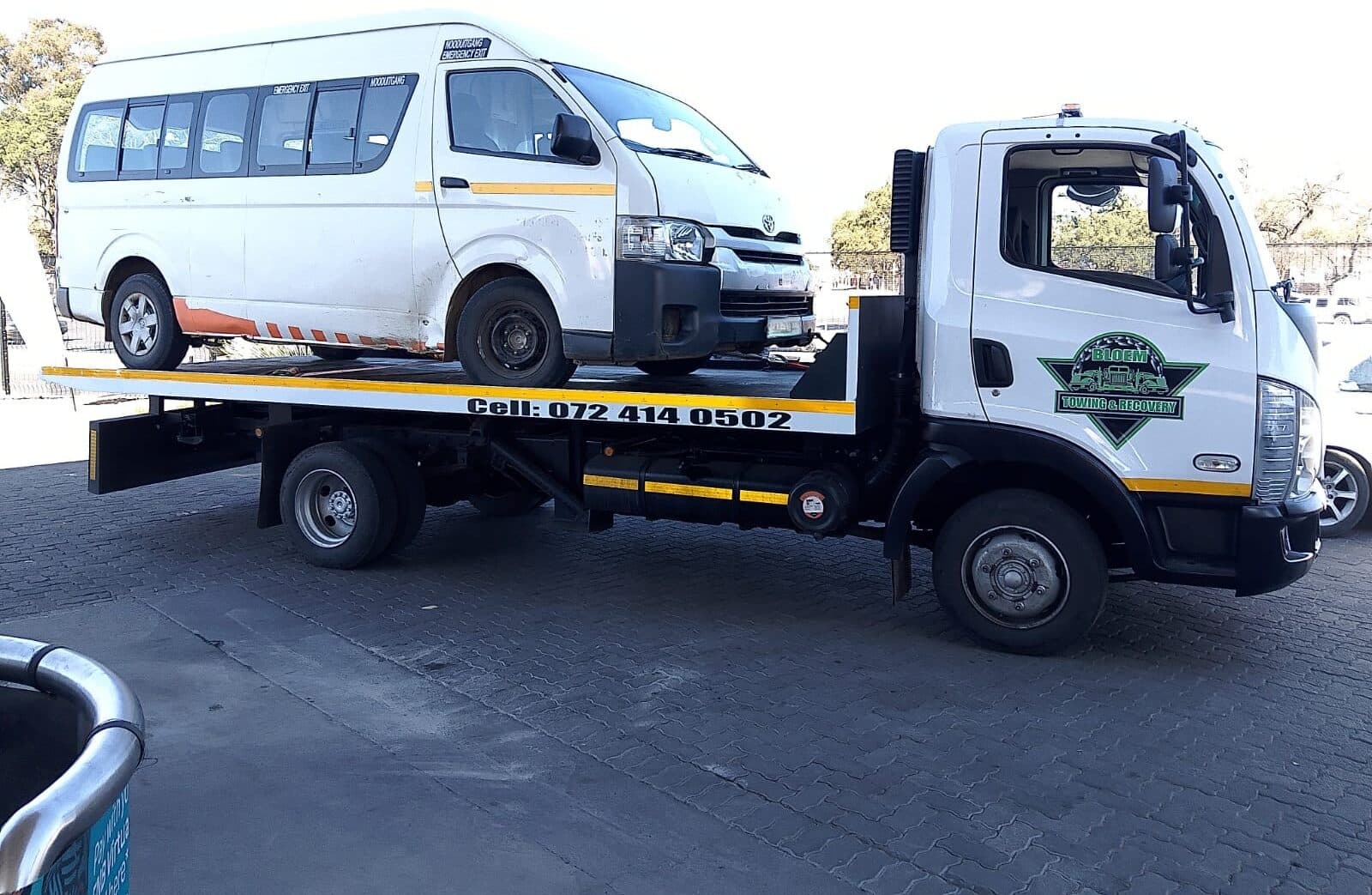 Passenger van loaded on a Bloem Towing flatbed truck